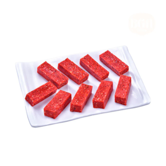 A white plate filled with rectangular pieces of Gulkand Burfi, showcasing its vibrant pinkish-red color and smooth texture