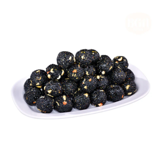 A white oval plate filled with black sesame and nut ladoos, showcasing their dark texture and nutty appearance